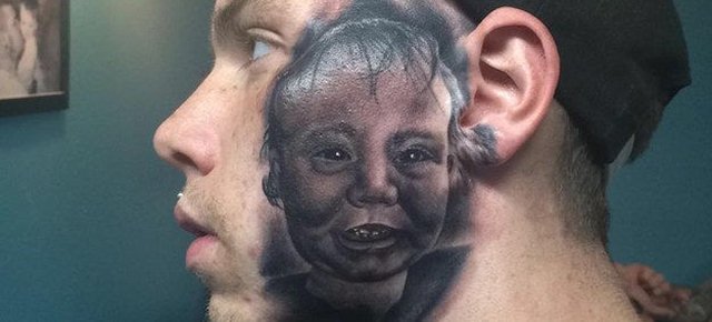 Si fa tatuare il volto del figlio in faccia