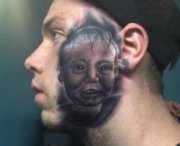 Si fa tatuare il volto del figlio in faccia
