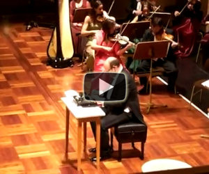 Si esibisce con una macchina da scrivere di fronte l'orchestra