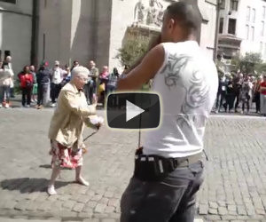 Una signora si ferma di fronte un artista di strada e inizia a ballare