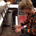 Un ragazzo si siete al pianoforte in un negozio e stupisce tutti