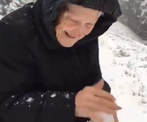 Una donna di 101 anni scende dall'auto e gioca con la neve