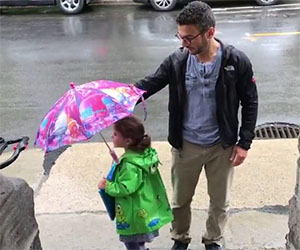 Papà e figlia hanno un solo ombrello. La soluzione? Simpaticissima!