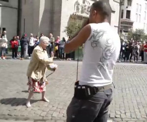 Una signora si ferma di fronte un artista di strada e inizia a ballare