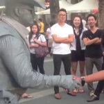 Statua umana picchia uomo